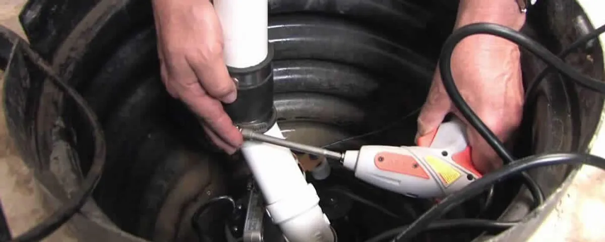 Sump pump installation technician connecting PVC discharge piping in Charlotte, NC